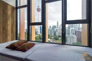 a bed with two pillows in a room with windows at Ceylonz Suite, Bukit Bintang, Experience in Kuala Lumpur