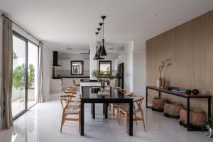 comedor y cocina con mesa negra y sillas en Villa Mullion Cove, en Bophut 