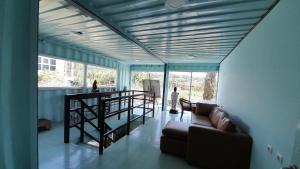 a living room with a couch and a large window at Rumah Container Bedugul in Bedugul