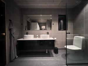 a bathroom with two sinks and a toilet and a mirror at Vinterdröm Idre Himmelfjäll in Idre