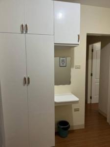 uma cozinha com armários brancos e um lavatório em ESTILO APARTMENT 2-storey em Loculan