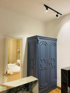 a blue cabinet in a room with a bedroom at Victorian Elegance Luxury Stays in Amritsar