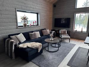 a living room with a blue couch and a tv at Vinterdröm Idre Himmelfjäll in Idre