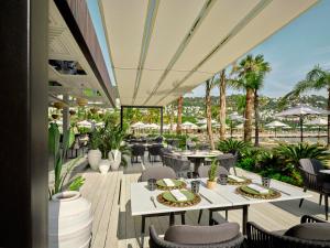 a restaurant with tables and chairs and palm trees at Caja by Maxx Royal in Bodrum City