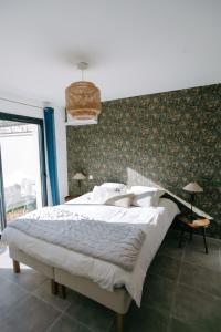 a bedroom with a large bed with a green wall at La Dolce Vita Provençale Charming House with its Private Swimming Pool in L'Isle-sur-la-Sorgue