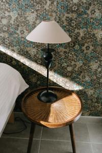 a lamp sitting on a table next to a bed at La Dolce Vita Provençale Charming House with its Private Swimming Pool in L'Isle-sur-la-Sorgue