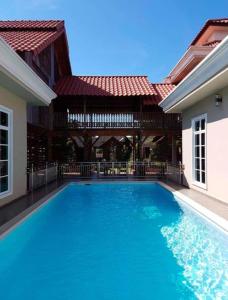 - une piscine en face d'une maison dans l'établissement Alia Express Villa Temila, à Pasir Puteh