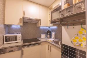 a small kitchen with white cabinets and a microwave at Weideglück-Zentral-Dampfdusche in Oberstaufen