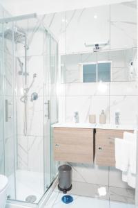 a white bathroom with a shower and a sink at Hostel Partenope in Naples