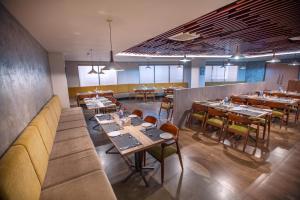 a restaurant with tables and chairs in a room at Raj Riveria Hotel in Mūvattupula