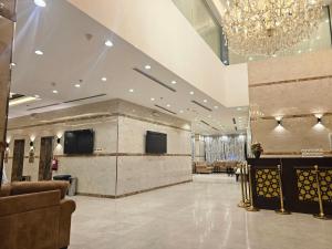 a lobby with a chandelier and a large room at فندق شاكر in Makkah