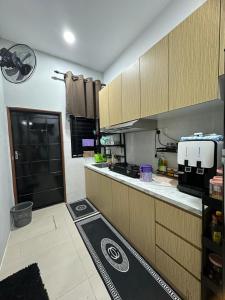 a kitchen with a counter and a kitchenasteryasteryasteryasteryasteryasteryasteryastery at Homestay Afeef Jerantut in Jerantut