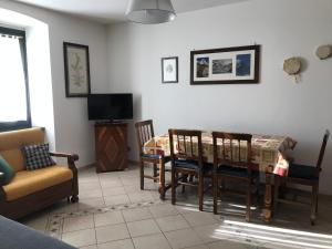 a living room with a table and chairs and a tv at Le Cherillon Apartment in Breuil-Cervinia