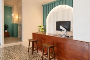 a room with a television and two stools at Bania Boutique House in Khao Lak