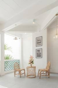 2 sillas y una mesa en una habitación con ventana en Bania Boutique House en Khao Lak