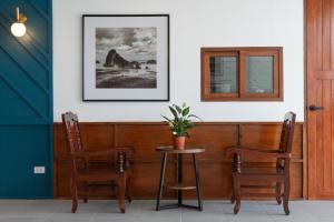 a table and two chairs and a picture on the wall at Bania Boutique House in Khao Lak