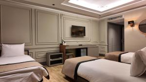 Lala Grand Hotel في أرزروم: غرفة فندقية بسريرين ومكتب