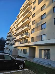 a black car parked in front of a tall building at Garsoniera Gabrielle in Braşov