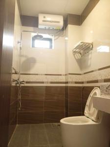 y baño con aseo, ventana y ducha. en Khách sạn Mimosa, en Kon Plong