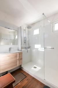 a white bathroom with a shower and a sink at Vue plongeante sur l'eau in Saint-Jean-de-Luz