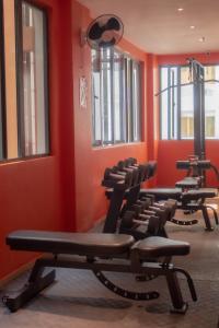 ein Fitnessraum mit mehreren Stühlen in einem Zimmer mit orangefarbenen Wänden in der Unterkunft Valentino's Hotel in Angeles