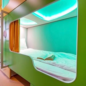a room with a bed with a book on it at Green Cube Capsule Hostel in Sofia