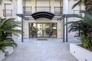 un accès à un bâtiment avec des palmiers devant lui dans l'établissement Carlton Riviera Cannes, à Cannes