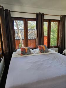 een slaapkamer met een groot wit bed en 2 ramen bij Horizon Resort in Ko Samed