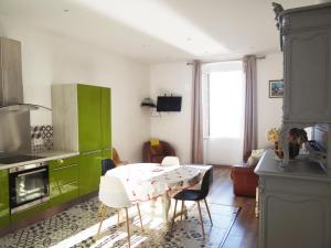 cocina con mesa con sillas y armario verde en T3 colonella, en Bastia