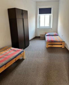 a room with two beds and a cabinet and a window at Hostel RK in Horažďovice