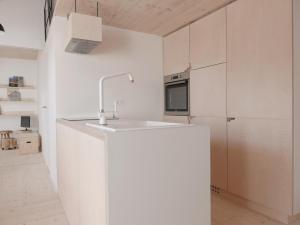 een keuken met witte kasten en een wastafel bij House Design Vipiteno in Vipiteno