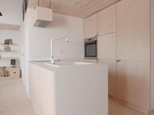 une cuisine avec des armoires blanches et un évier dans l'établissement House Design Vipiteno, à Vipiteno