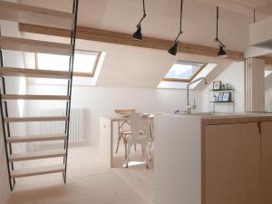 een keuken en eetkamer met een ladder en een tafel bij House Design Vipiteno in Vipiteno