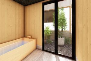 sauna con vasca da bagno e piante in vaso di Dai Onsen Matsudaya Ryokan a Hanamaki