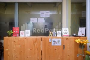 un mostrador de madera con letreros encima en Travelista Homestay near GOR Candradimuka Semarang Mitra RedDoorz, en Srondolwetan