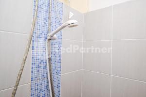 y baño con ducha y azulejos azules. en Travelista Homestay near GOR Candradimuka Semarang Mitra RedDoorz, en Srondolwetan 33 fotos más