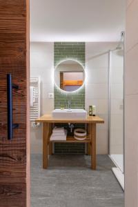 a bathroom with a sink and a mirror at PAPILL'ON - Boutique Hotel in La Tzoumaz