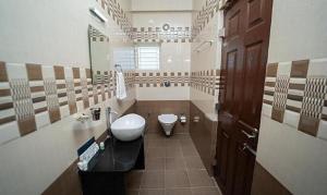 a bathroom with a sink and a toilet in it at FabHotel Panchami Comforts in Bangalore