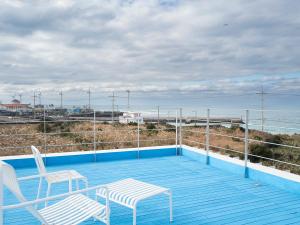 a balcony with two chairs and a view of the ocean at Boutique Pool Villa NAMIB in Jeju