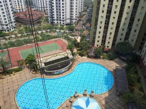 an overhead view of a large swimming pool with a tennis court at Apartemen Mediterania Palace Residence Kemayoran Jakarta Pusat in Jakarta