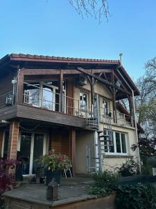 a house with a deck and a balcony at Rivière et jardin à vos pieds in Pulligny