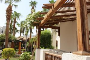eine Pergola an der Seite eines Hauses mit Palmen in der Unterkunft Herrmes Hostel in Sharm El Sheikh