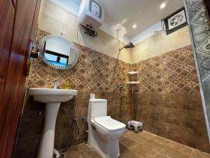 a bathroom with a toilet and a sink and a mirror at Rabha Stay 2BHK Penthouse with Terrace in Rishīkesh