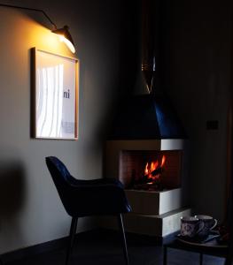 ビアンカヴィッラにあるPODERE DELL'ETNA SEGRETA - Essential Nature Hotelの椅子と暖炉付きの暗室です。