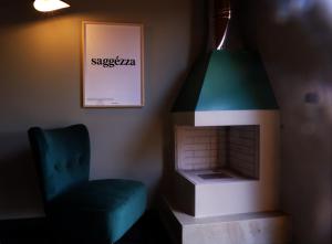 ein Wohnzimmer mit einem Kamin und einem blauen Stuhl in der Unterkunft PODERE DELL'ETNA SEGRETA - Essential Nature Hotel in Biancavilla