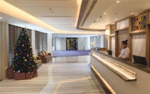 ein Weihnachtsbaum in der Lobby eines Hotels in der Unterkunft Aqueen Prestige Hotel Lavender in Singapur