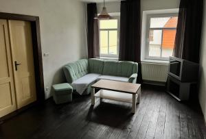 a living room with a green couch and a coffee table at Hostel RK in Horažďovice