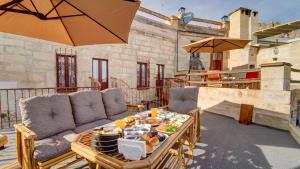 ネヴシェヒルにあるLa Vie Cappadocia Suitesのパティオ(ソファ、テーブル、食べ物付)
