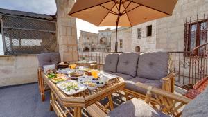 a patio with a table with food and an umbrella at La Vie Cappadocia Cave in Nevşehir