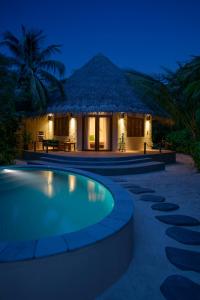 a resort with a swimming pool at night at Coco Palm Dhuni Kolhu in Thulhaadhoo
